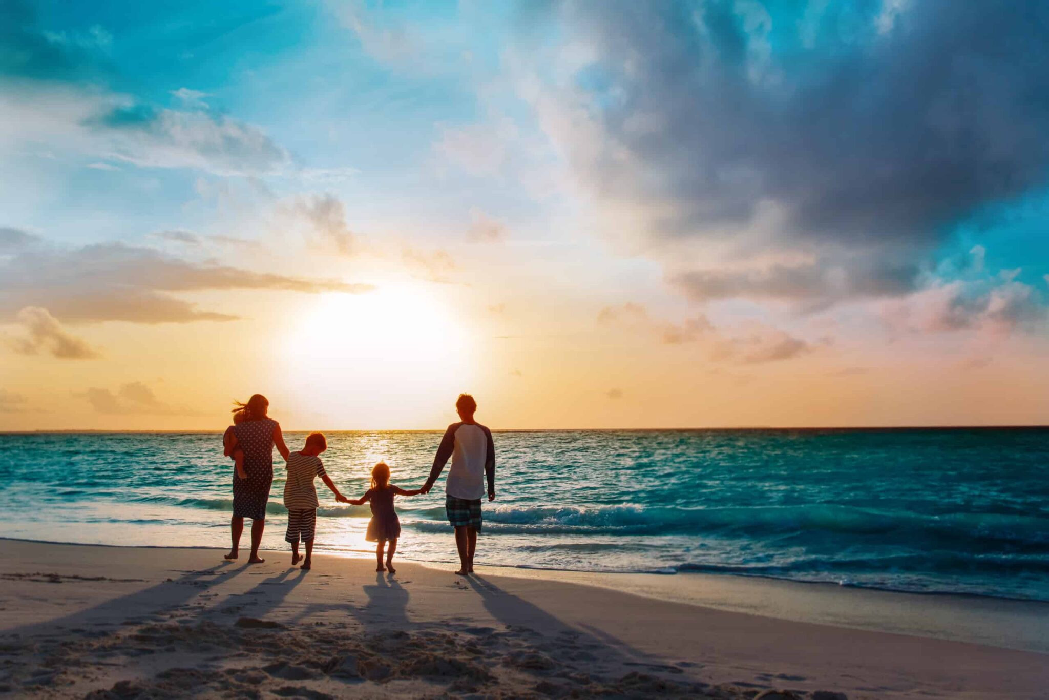 Eine Familie läuft den Strand entlang