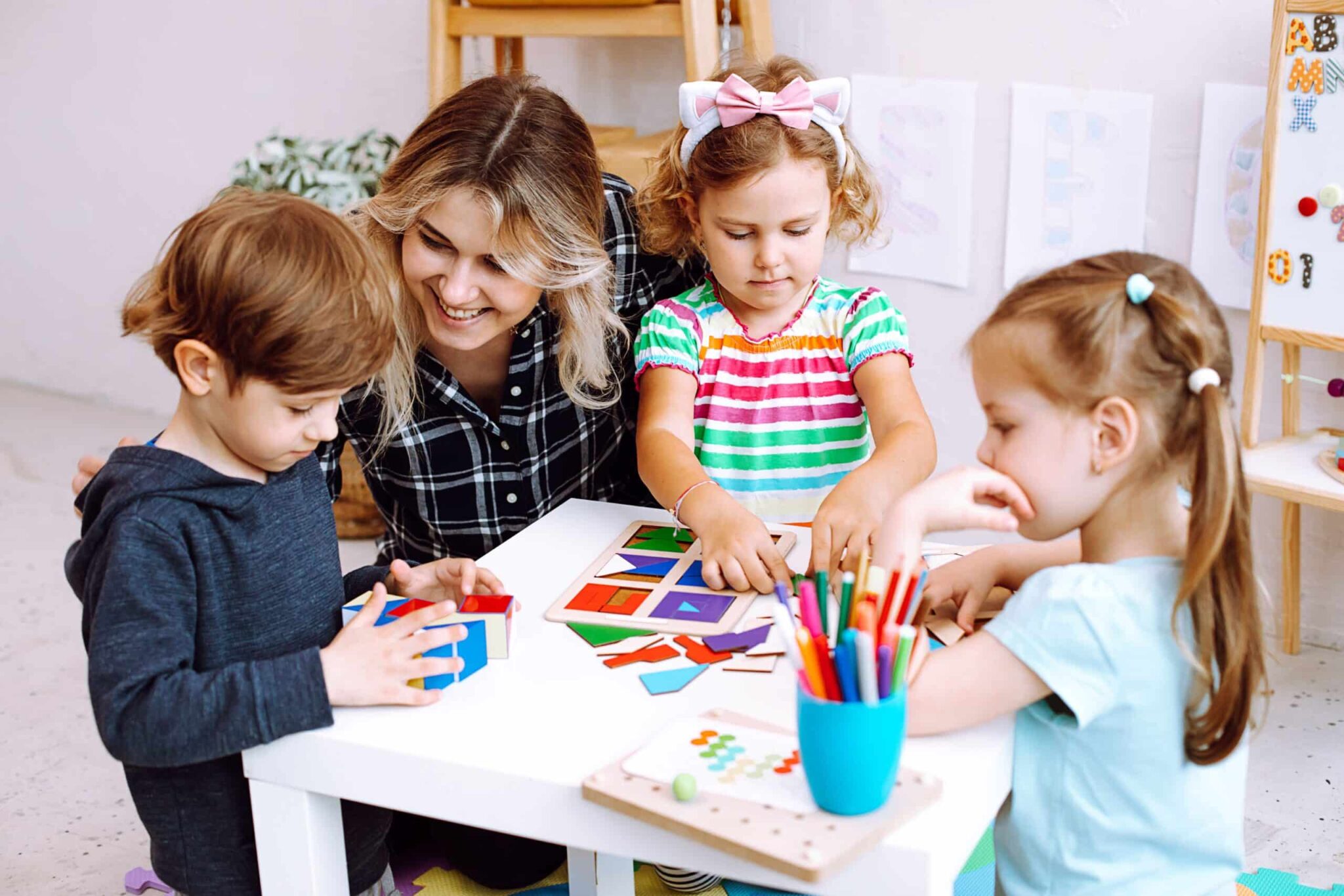 Eine Kindergärtnerin malt mit Kindern