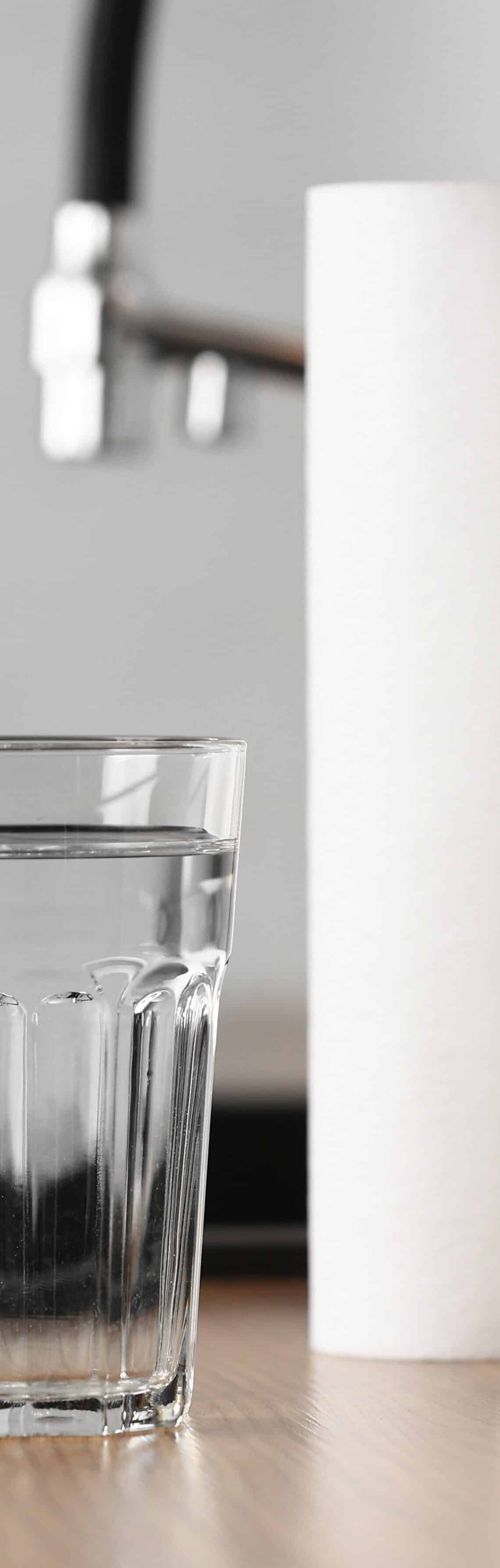 Ein Glas Wasser neben Filterkartuschen