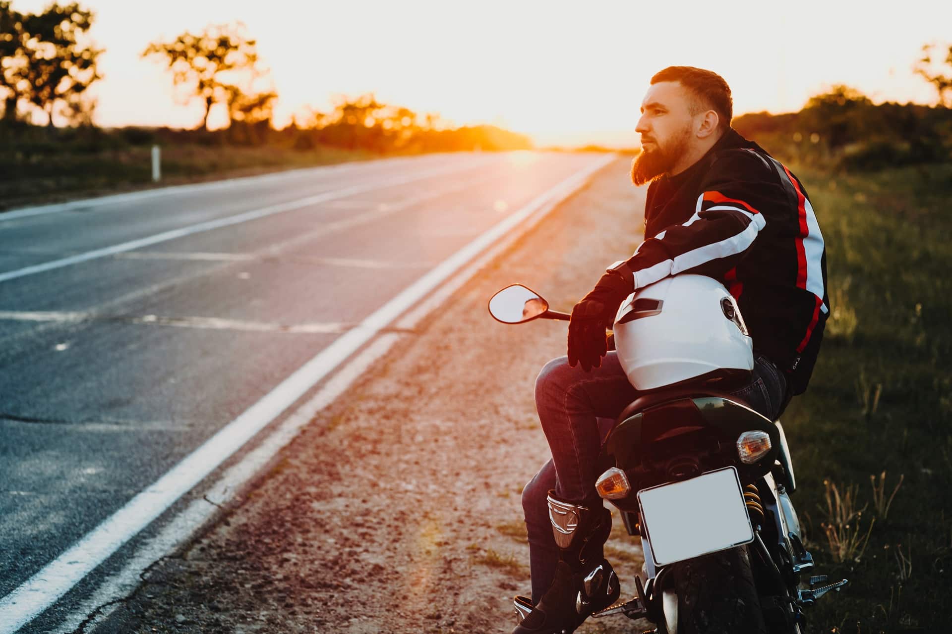 Mann sitzt mit Helm auf Motorrad | Dainese