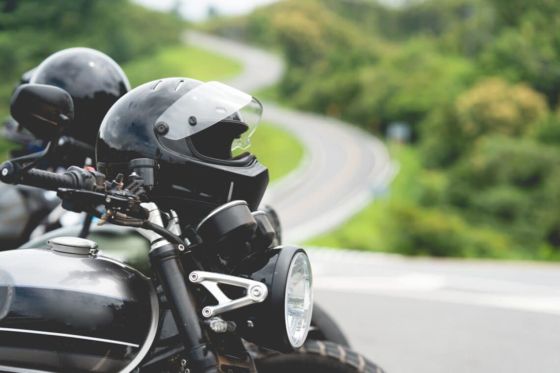 Motorradhelm auf Lenker vor Kurve | Dainese