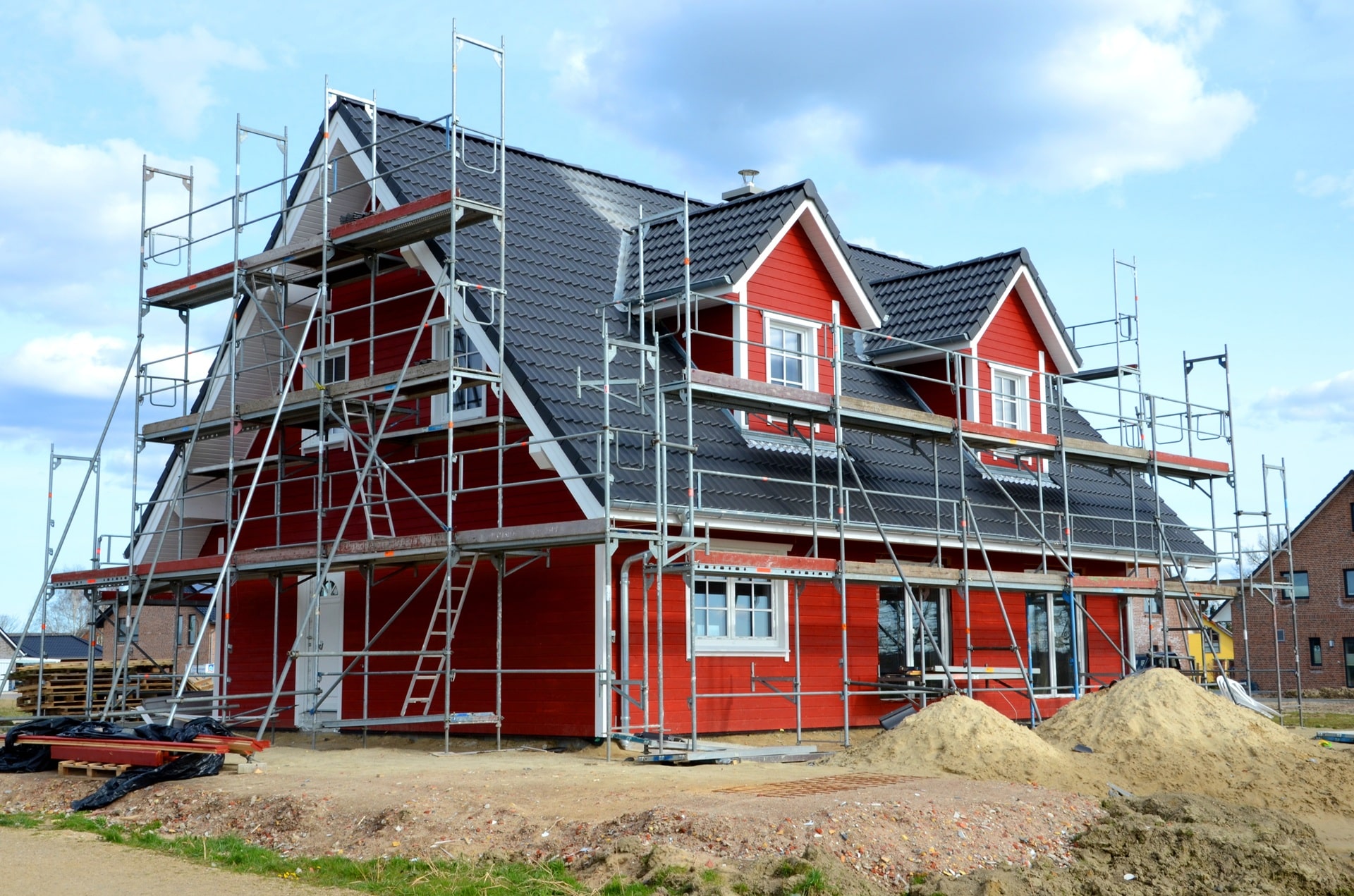 Haus mit Gerüst bei Fassadenarbeiten | Scherenbühnen mieten