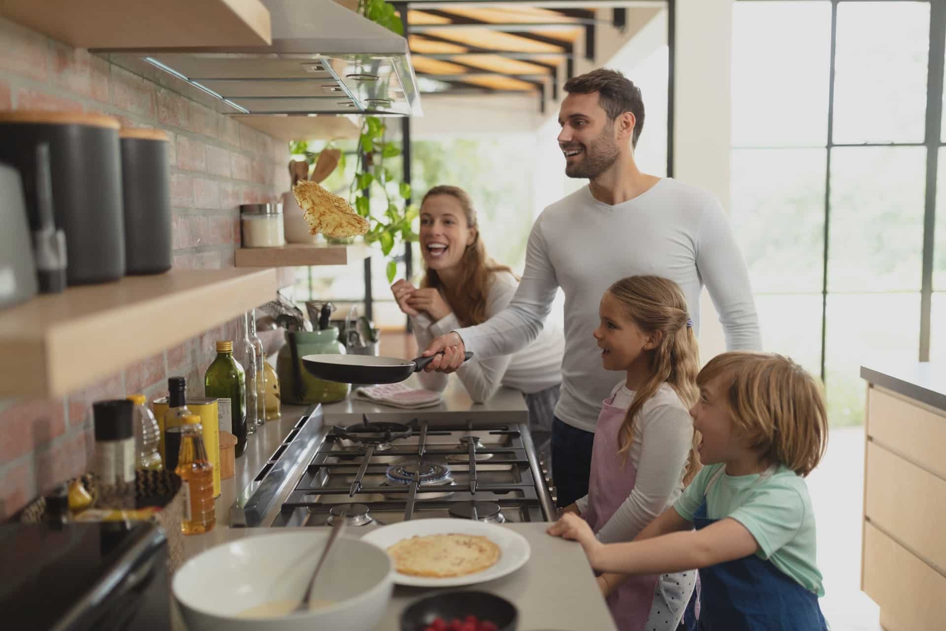 Familie backt Pfannkuchen in moderner Küche | Entkalkungsanlage