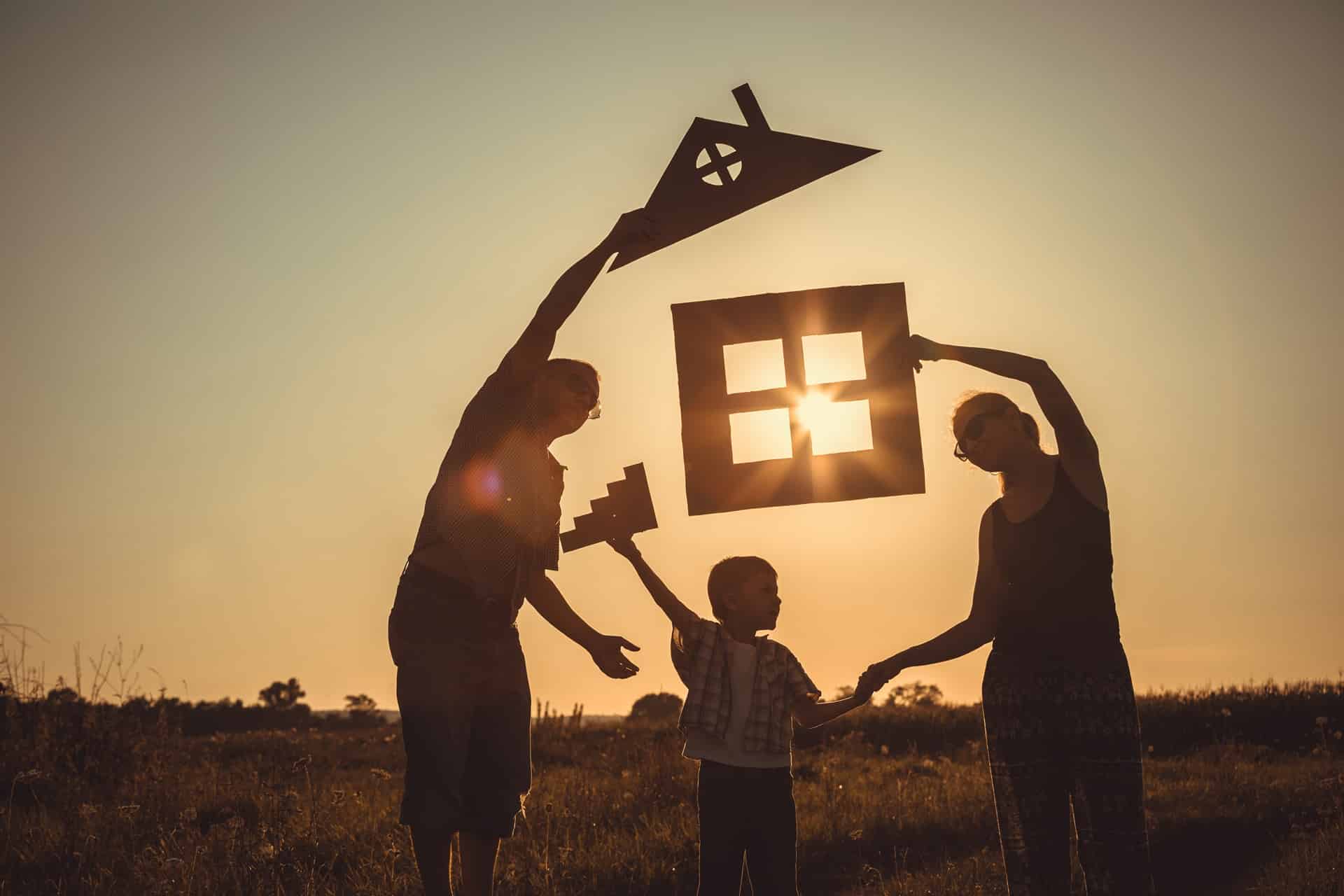 Familie mit Haussilhouetten bei Sonnenuntergang | Sitzbank vor dem Bett