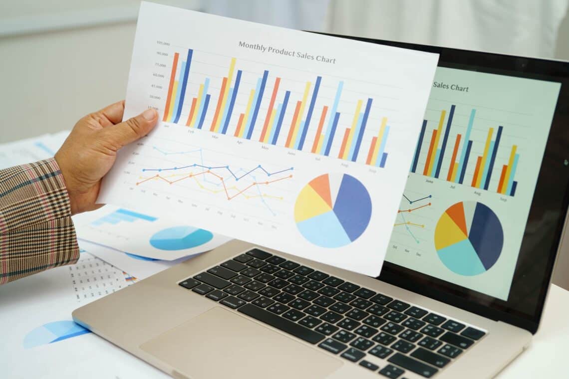 Person analysiert bunte Diagramme mit Finanzdaten | Lohnabrechnung online