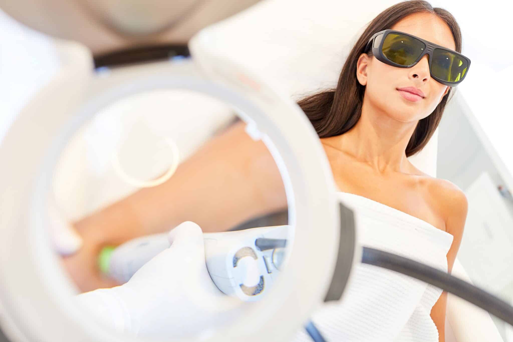 Junge Frau mit Schutzbrille bei der Laserepilation