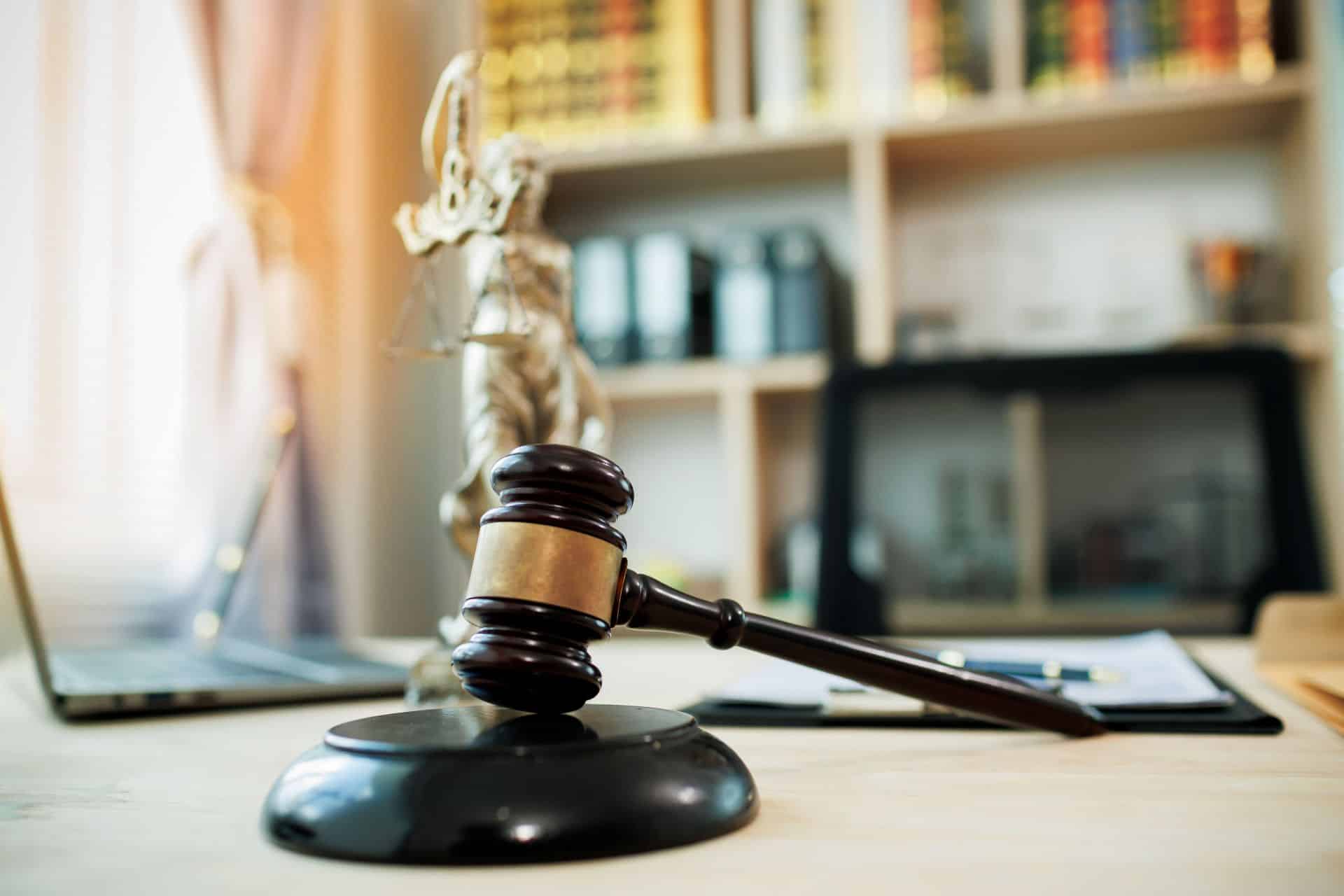 Gerichtshammer und Justitia im Anwaltsbüro als Symbol für Revision im Strafrecht